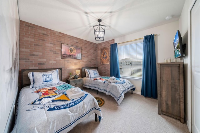 bedroom with carpet floors, brick wall, and a notable chandelier