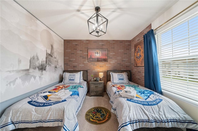 bedroom with multiple windows, brick wall, and an inviting chandelier