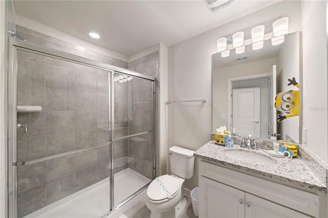 bathroom featuring vanity, toilet, and a shower with door