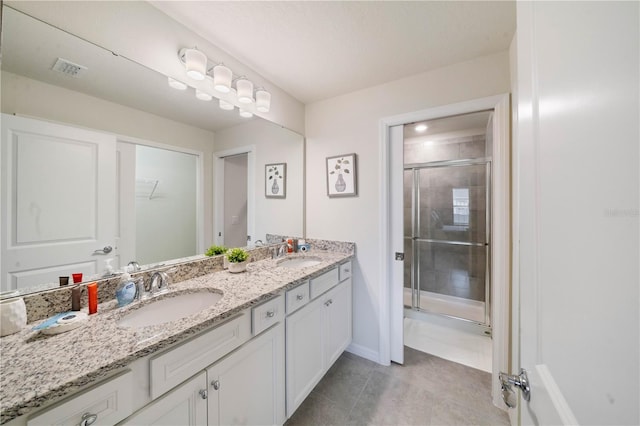 bathroom featuring tile patterned flooring, vanity, and an enclosed shower