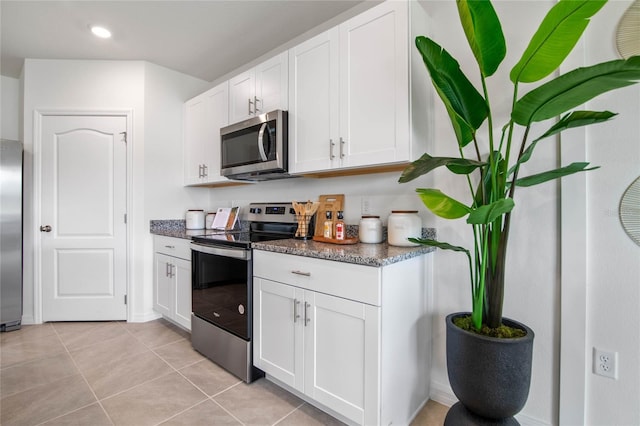 kitchen featuring white cabinets, light tile patterned flooring, and appliances with stainless steel finishes