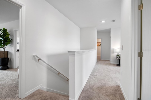 hallway featuring light colored carpet