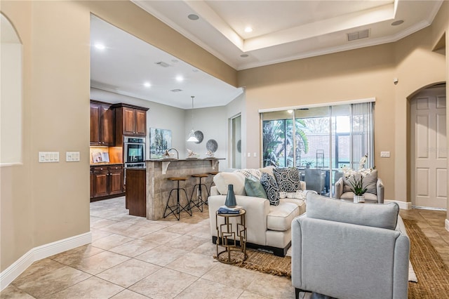 living room with a raised ceiling, crown molding, sink, and light tile patterned floors