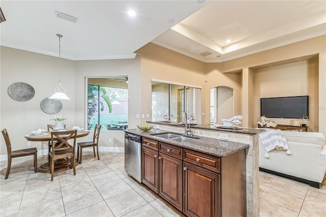 kitchen with dishwasher, a kitchen island with sink, dark stone counters, sink, and hanging light fixtures