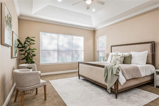 carpeted bedroom with ceiling fan and a tray ceiling