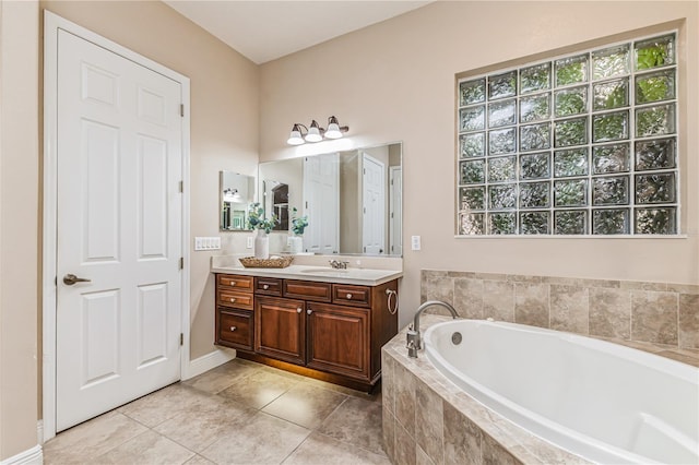 bathroom with vanity, a relaxing tiled tub, and tile patterned floors