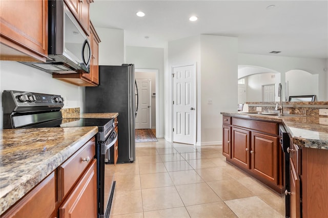 kitchen featuring black range with electric stovetop, light stone counters, sink, and light tile patterned floors