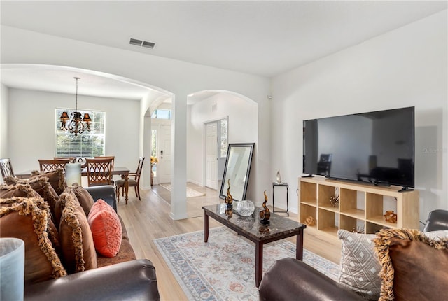 living room with a chandelier and light wood-type flooring