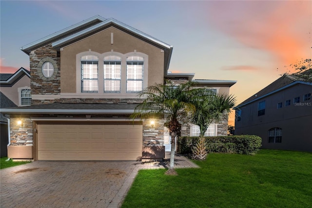 view of front of home with a yard and a garage