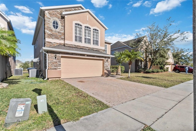 view of front facade with a front lawn, a garage, and cooling unit