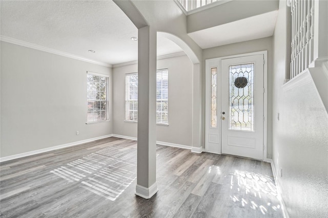 foyer featuring crown molding, wood-type flooring, and a textured ceiling