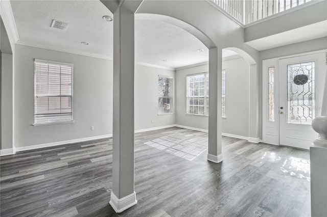 entrance foyer featuring a textured ceiling, ornamental molding, and dark wood-type flooring