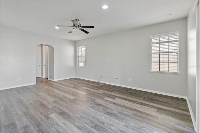 unfurnished room with a wealth of natural light, ceiling fan, and hardwood / wood-style flooring