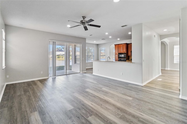 unfurnished living room with ceiling fan and hardwood / wood-style flooring