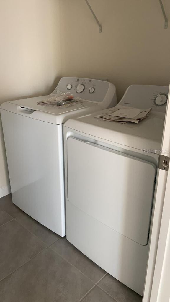 washroom featuring laundry area, washer and clothes dryer, and tile patterned floors