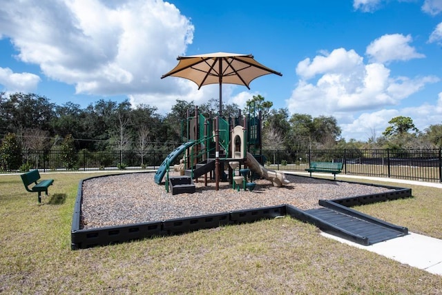 community play area featuring fence and a yard