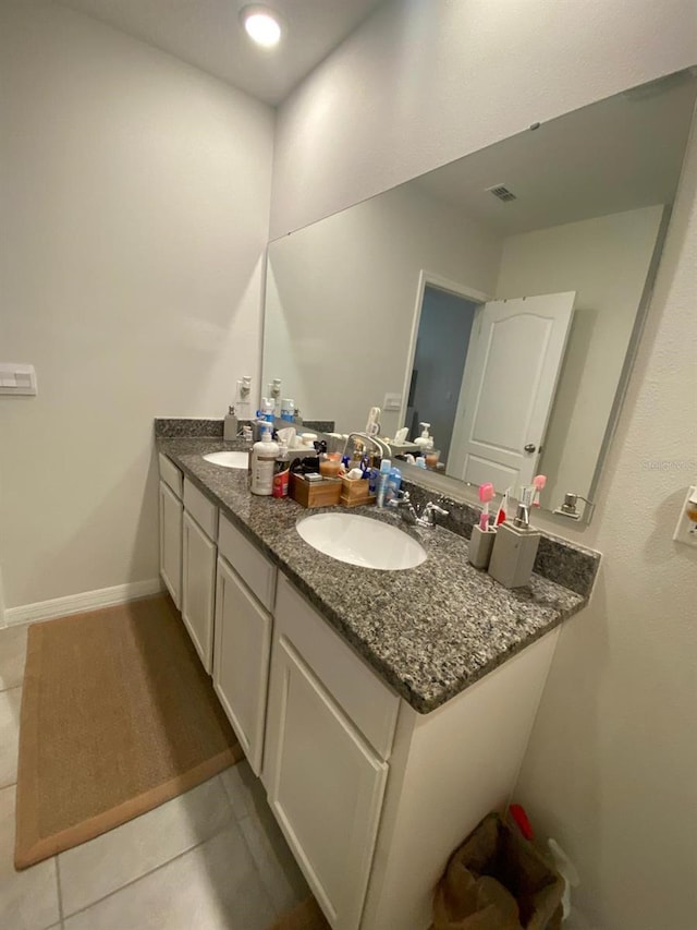 full bathroom featuring tile patterned flooring, visible vents, double vanity, and a sink