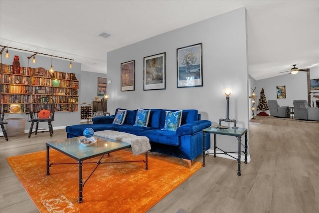 living room with rail lighting, light hardwood / wood-style floors, and ceiling fan