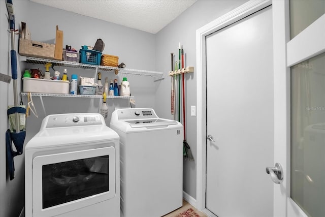 laundry room featuring a textured ceiling and separate washer and dryer