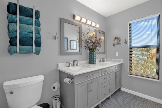 bathroom with tile patterned floors, a wealth of natural light, vanity, and toilet