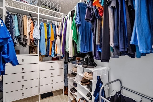 walk in closet with light hardwood / wood-style floors