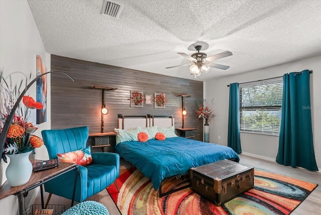 1608 Bomi Cir, Winter Park, FL 32792 - bedroom with wood walls, wood finished floors, a ceiling fan, a textured ceiling, and an accent wall