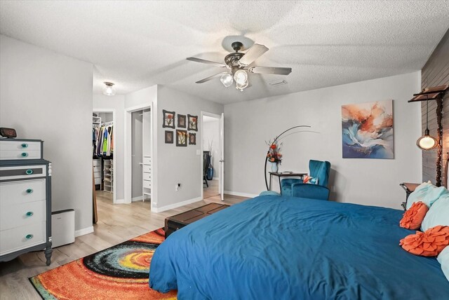 1608 Bomi Cir, Winter Park, FL 32792 - bedroom featuring light wood-style flooring, a spacious closet, a ceiling fan, a textured ceiling, and a closet