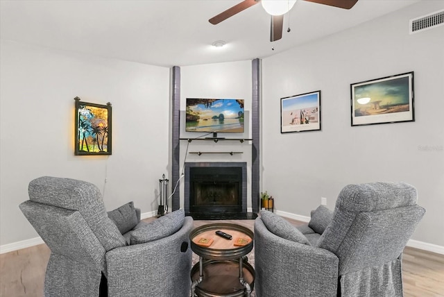1608 Bomi Cir, Winter Park, FL 32792 - living room featuring light wood-style flooring, a ceiling fan, and a brick fireplace