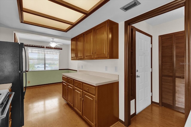 kitchen featuring ceiling fan, black refrigerator, range, and light hardwood / wood-style floors