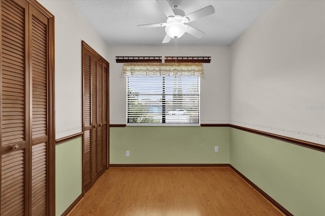 interior space with ceiling fan, light hardwood / wood-style floors, and a textured ceiling