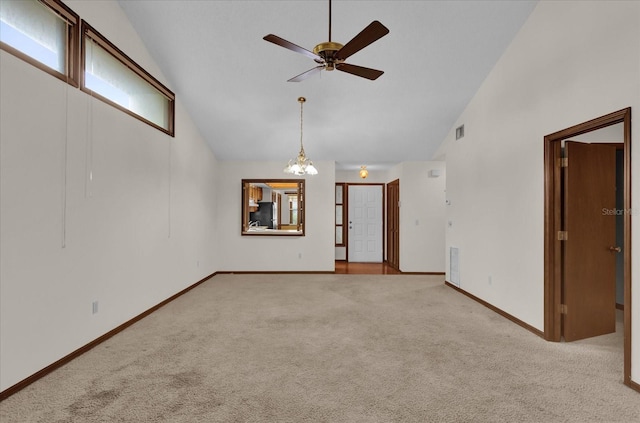 unfurnished room with high vaulted ceiling, ceiling fan with notable chandelier, and light colored carpet