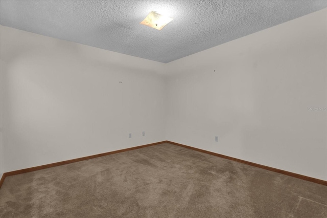 carpeted empty room featuring a textured ceiling