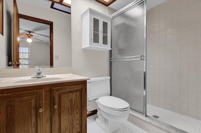 bathroom with tile patterned floors, toilet, vanity, a shower with door, and ceiling fan