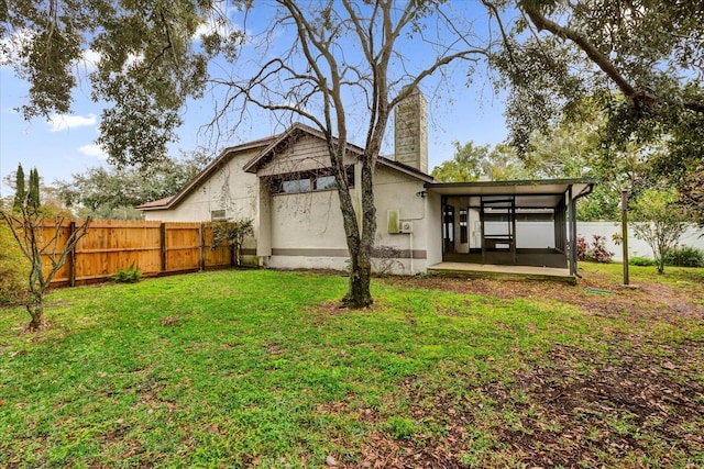 rear view of house featuring a patio and a yard