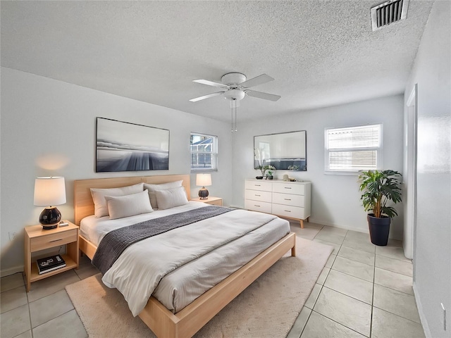 tiled bedroom with a textured ceiling and ceiling fan