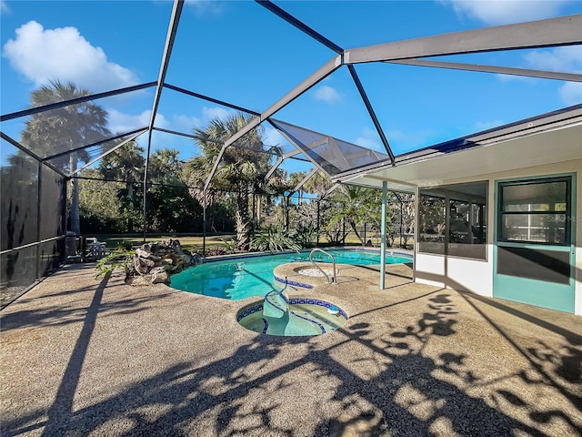 view of swimming pool featuring a lanai, a patio, and a hot tub