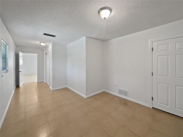 2448 S Daytona Ave, Flagler Beach, FL 32136 - empty room featuring a textured ceiling and light tile patterned floors