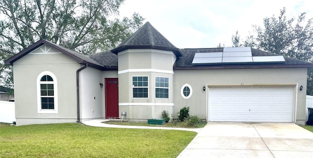 view of front of property featuring solar panels, a garage, and a front yard