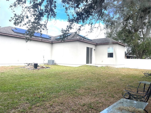 back of house featuring a yard and central AC