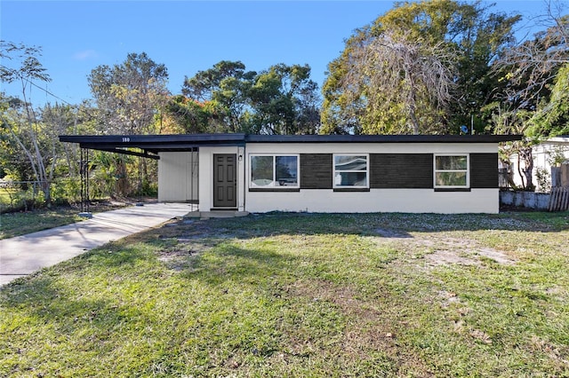 ranch-style house with a front yard and a carport