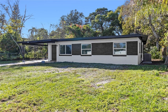 view of property exterior with a yard, cooling unit, and a carport