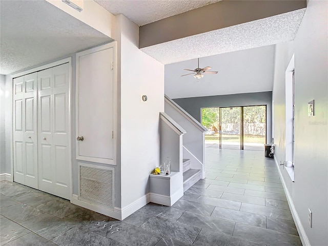 hall featuring a textured ceiling