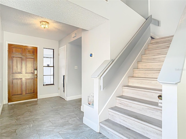 foyer entrance featuring a textured ceiling