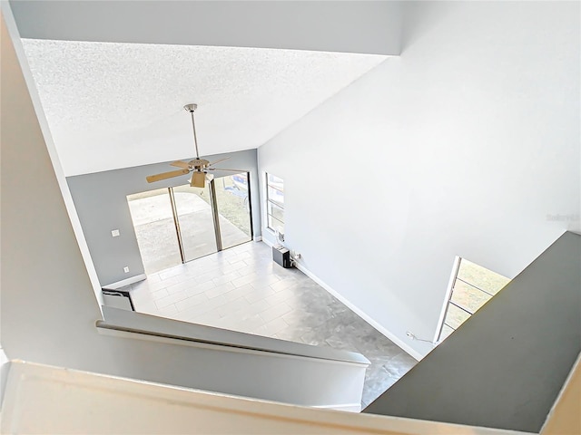 stairway featuring a textured ceiling, ceiling fan, lofted ceiling, and tile patterned floors