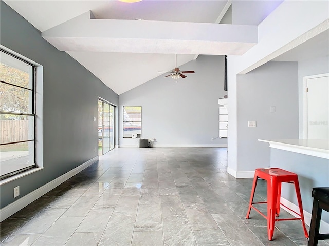 unfurnished living room with high vaulted ceiling and ceiling fan