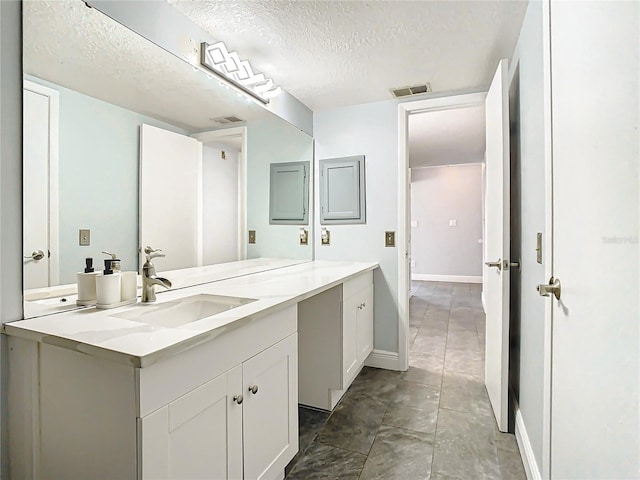 bathroom featuring a textured ceiling and vanity