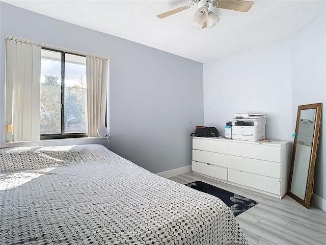 bedroom with multiple windows, ceiling fan, and light wood-type flooring