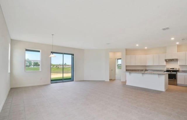 kitchen featuring stainless steel electric range oven, decorative light fixtures, white cabinets, a kitchen bar, and a kitchen island with sink