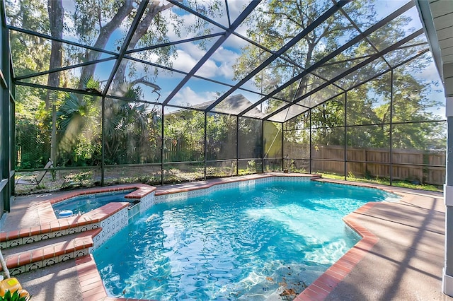 view of swimming pool with a lanai and an in ground hot tub