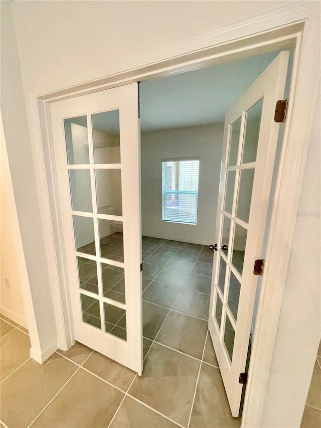 hall featuring tile patterned flooring and french doors